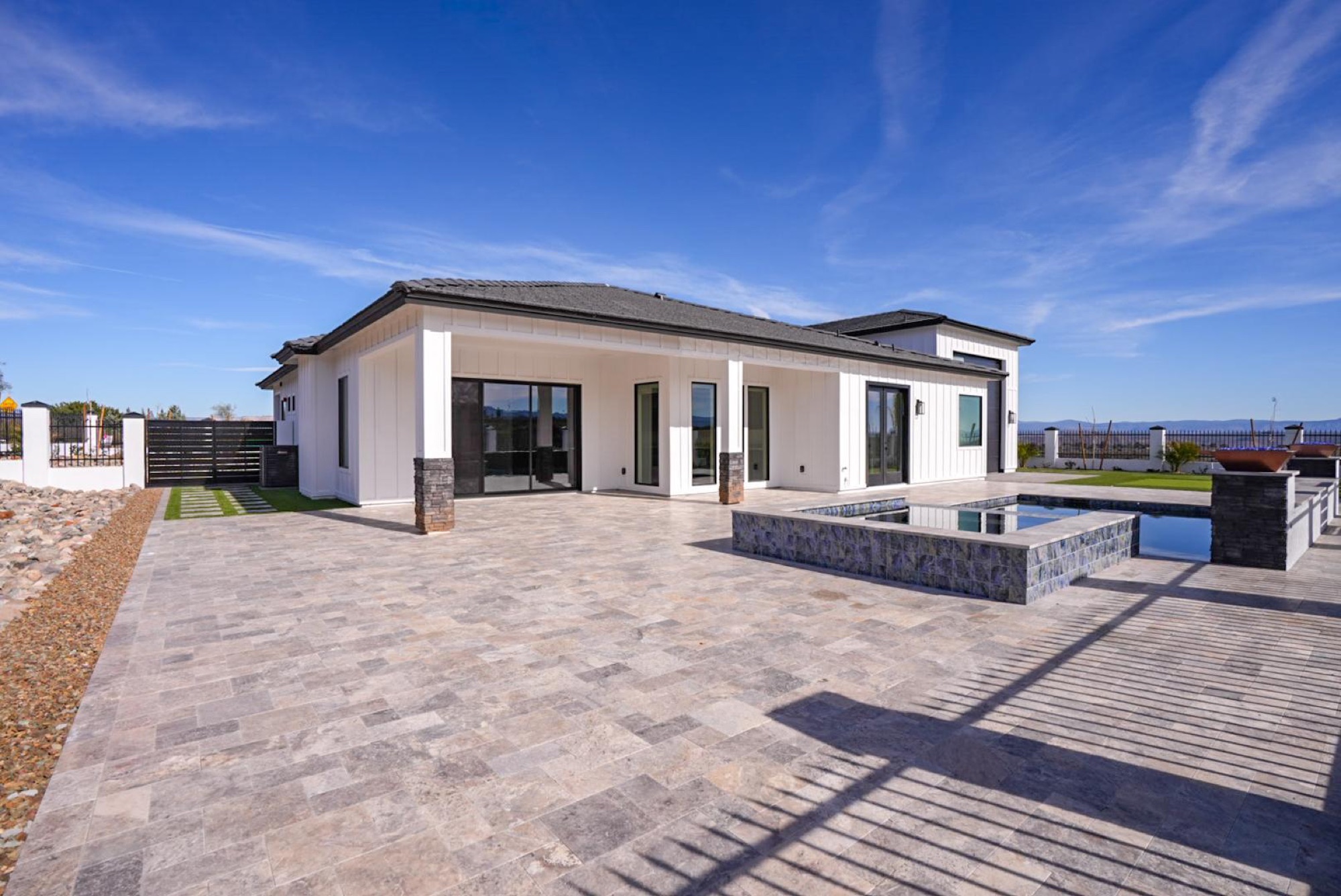 Travertine pool deck and the home in daylight