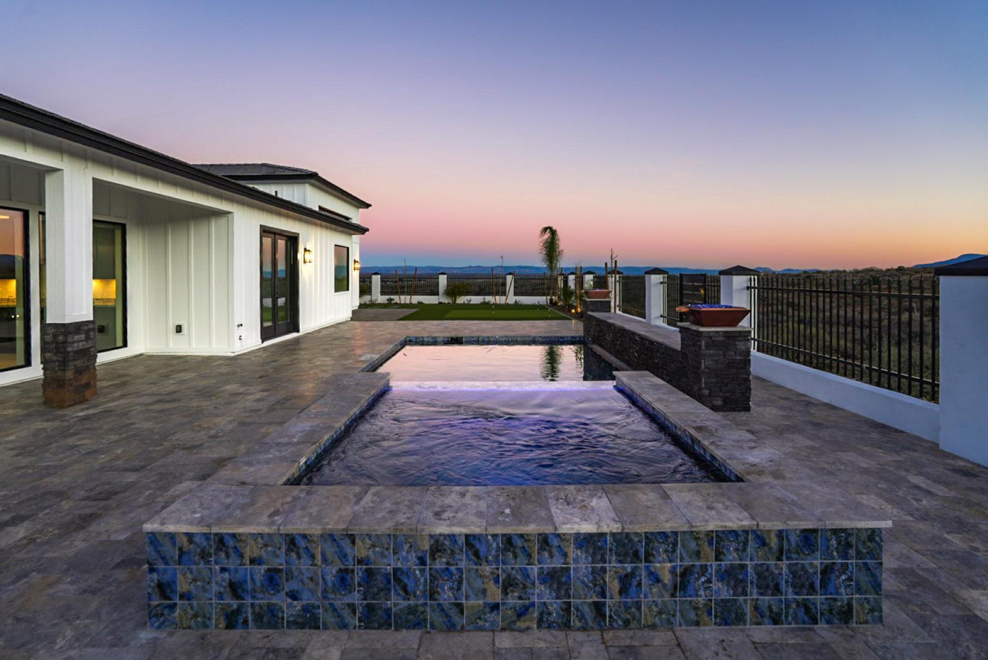 Pool and raised spa beneath a sunset sky