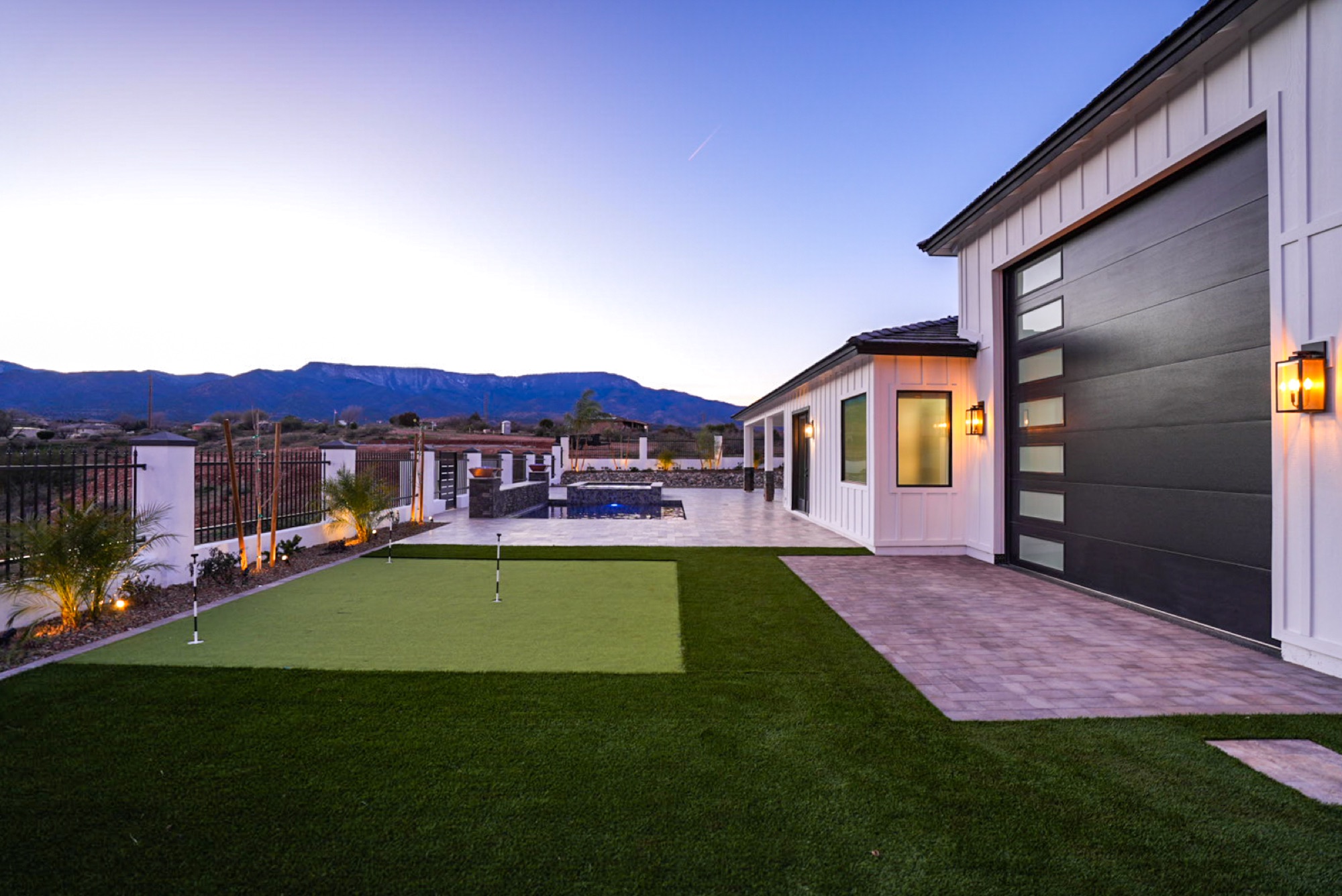 Putting green and pool at dusk beneath the Mingus Mountains