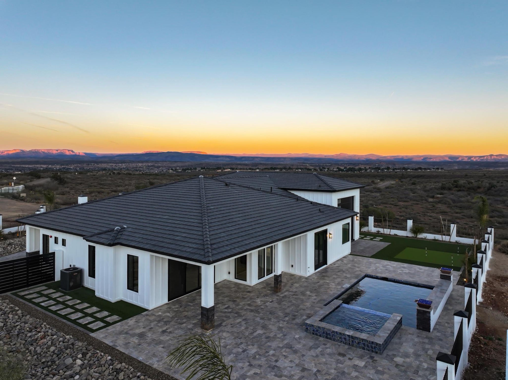 Aerial view of the home and pool at dusk