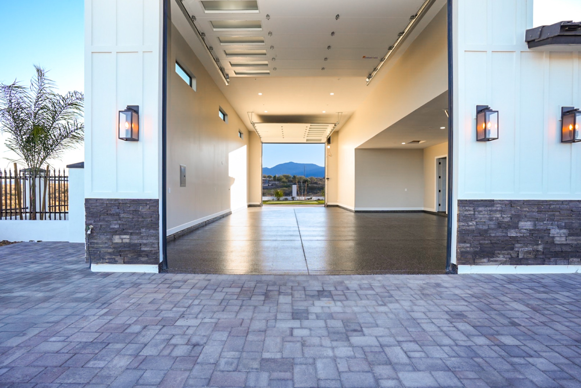 Stone-trimmed RV garage entrance at dusk with lanterns lit